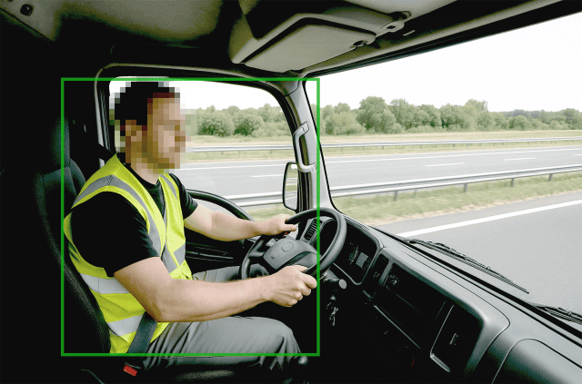 Driver monitoring system assessing a commercial truck driver on the highway.